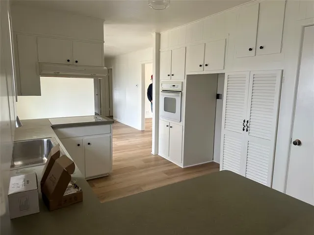 a view of a kitchen with refrigerator and white cabinets