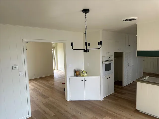 a view of a kitchen with refrigerator and wooden floor