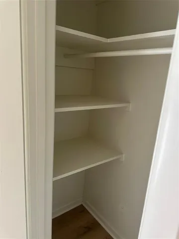 a view of walk in closet with empty racks