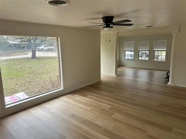 a view of a room with wooden floor and a floor to ceiling window