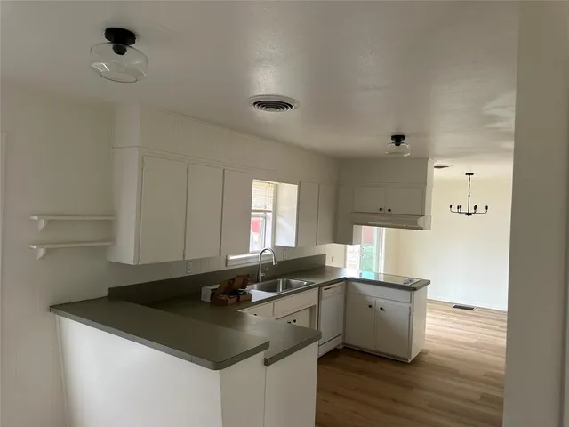 a kitchen with a sink cabinets and wooden floor