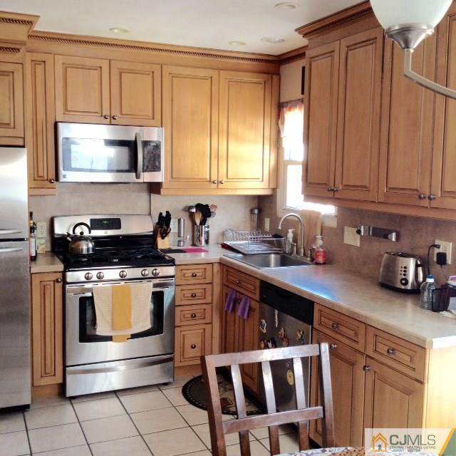 198 McFarlane Road Colonia, NJ 07067 - Photo 4 of 22 a kitchen with stainless steel appliances granite countertop a stove a sink and a microwave