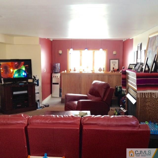 198 McFarlane Road Colonia, NJ 07067 - Photo 8 of 22 a living room with furniture a flat screen tv and a fireplace
