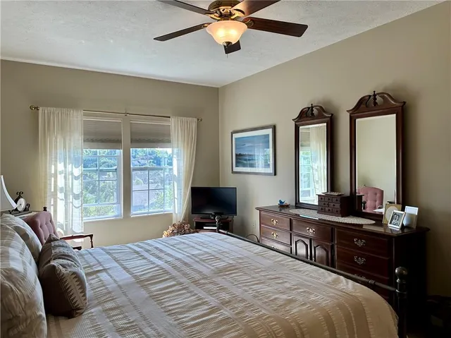 a bedroom with a bed and a dresser next to a window