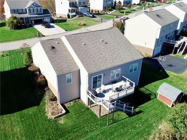 an aerial view of a house with a yard and trees