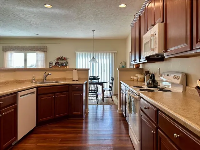a kitchen with stainless steel appliances granite countertop wooden cabinets a stove top oven a sink and dishwasher