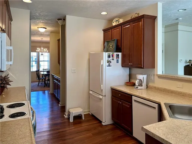 a kitchen with granite countertop a refrigerator and a sink