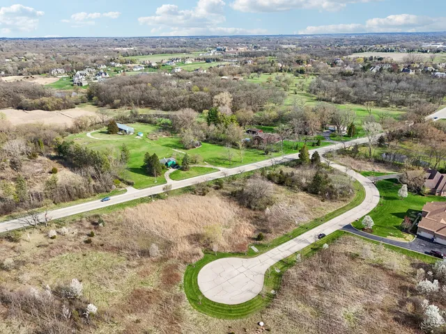 an aerial view of a house with a yard and lake view