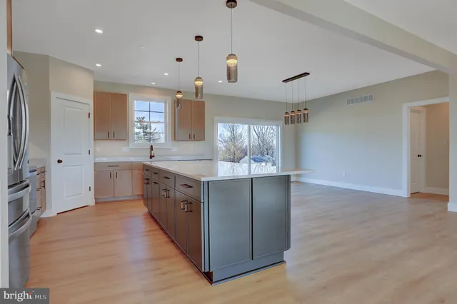 a large kitchen with a large counter top sink and stainless steel appliances