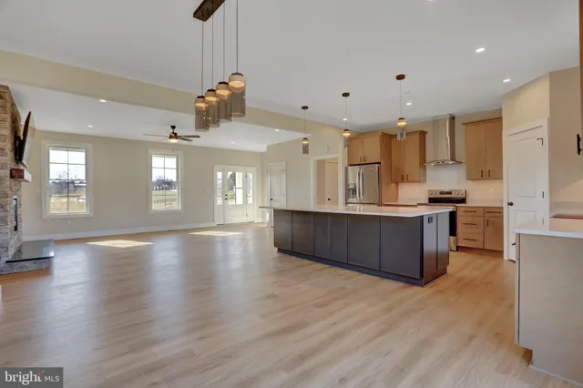 a view of kitchen with kitchen island wooden floor center island and stainless steel appliances