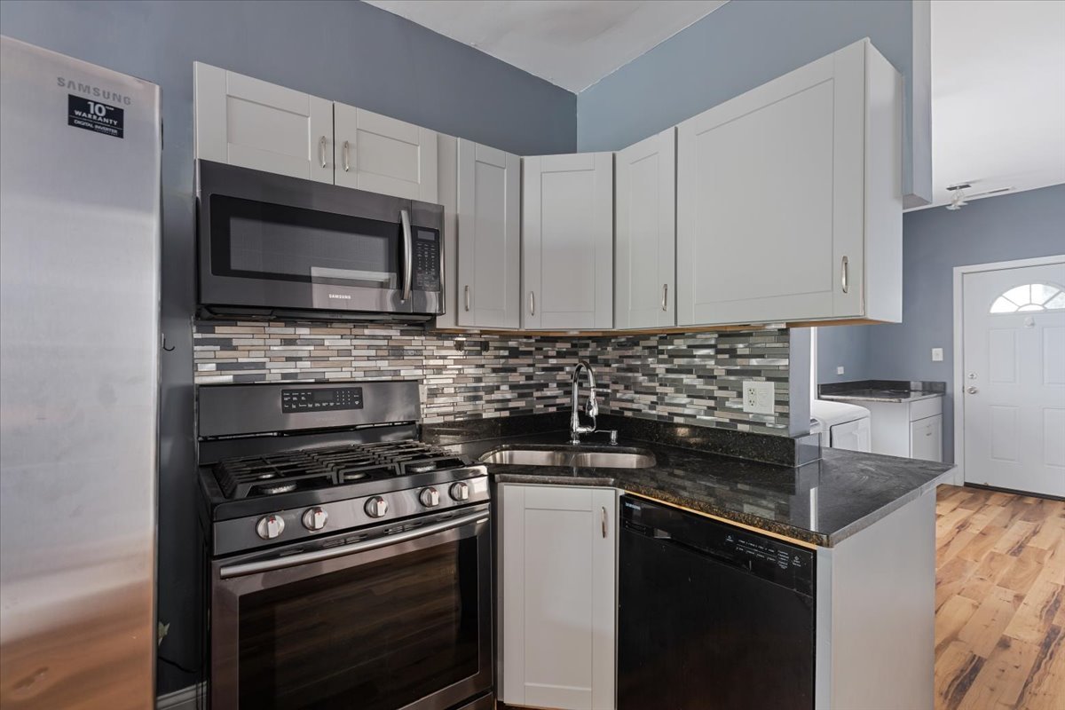 2062 North Damen Avenue Chicago, IL 60647 - Photo 9 of 26 a kitchen with granite countertop a sink stove and microwave