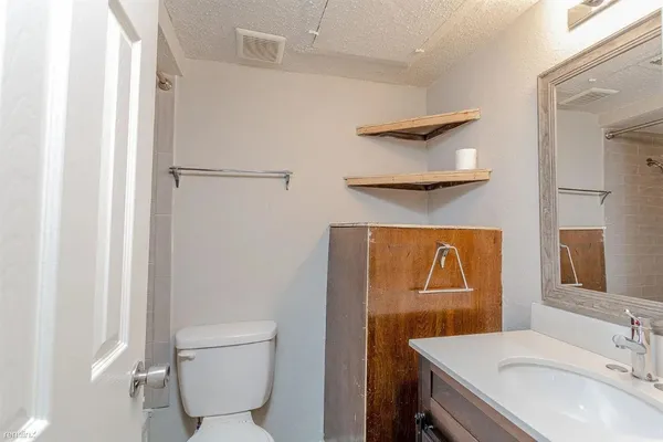 a bathroom with a sink a toilet and a mirror