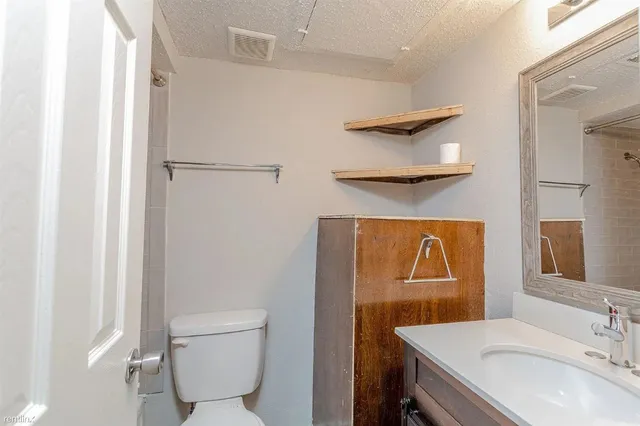 a bathroom with a sink a toilet and a mirror