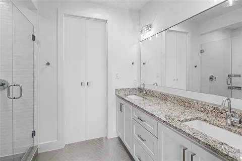a bathroom with a granite countertop sink and white shower