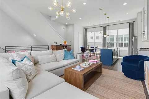 a living room with furniture kitchen and a table