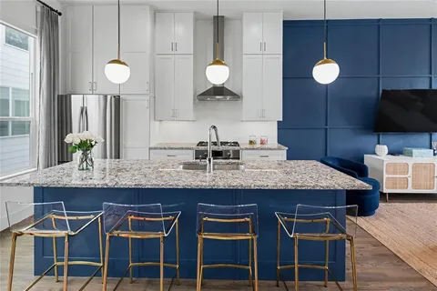 a kitchen with granite countertop a sink and a refrigerator