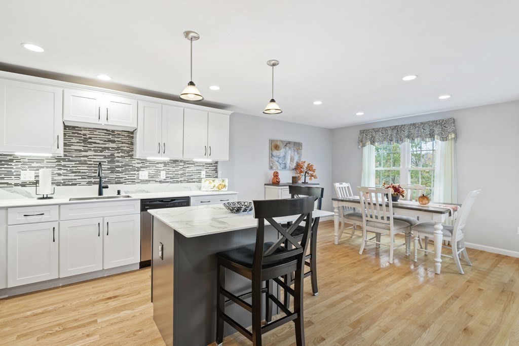 21 Honeysuckle Road Worcester, MA 01607 - Photo 13 of 38 a kitchen with stainless steel appliances granite countertop a stove a sink a dining table and chairs with wooden floor