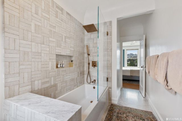 a bathroom with a tub shower and a sink