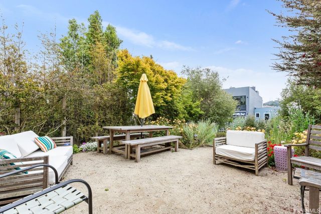 a view of a patio with a table and chairs and a barbeque
