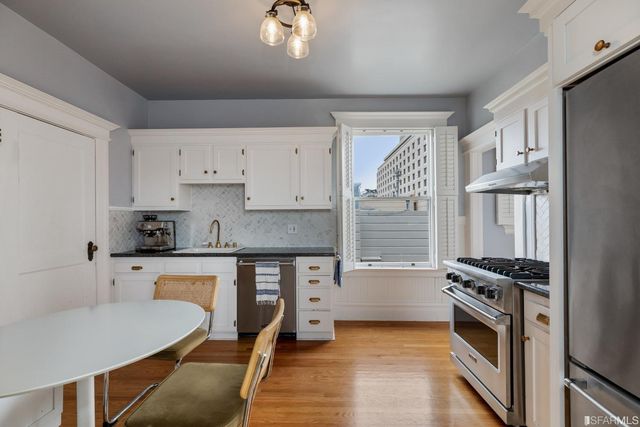 a kitchen with granite countertop a stove a sink and a refrigerator