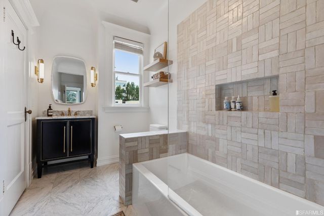 a bathroom with a tub sink and mirror