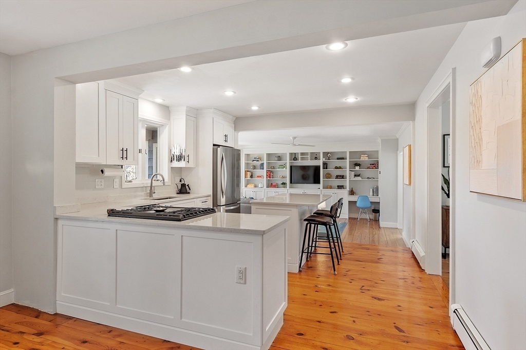 4 Willow Road Harvard, MA 01451 - Photo 12 of 42 a kitchen with stainless steel appliances granite countertop a stove top oven a sink a dining table and chairs with wooden floor