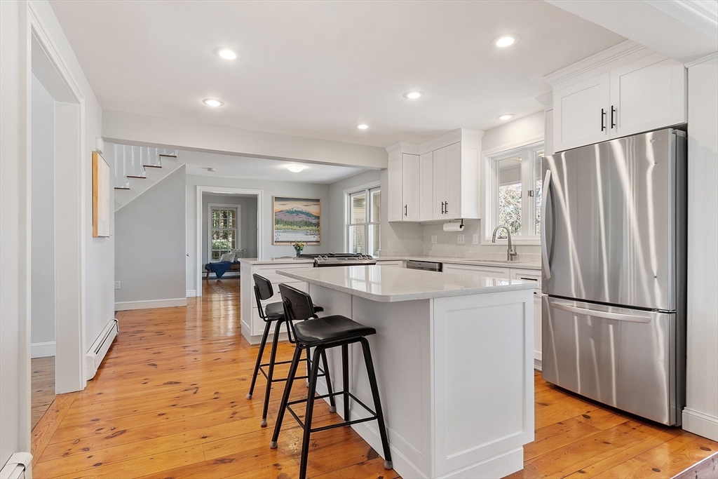 4 Willow Road Harvard, MA 01451 - Photo 14 of 42 a kitchen with stainless steel appliances a refrigerator a stove a sink dishwasher and a dining table with wooden floor