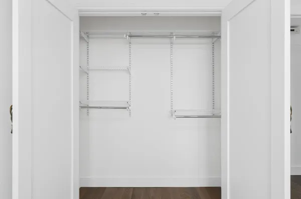 a view of walk in closet with empty racks