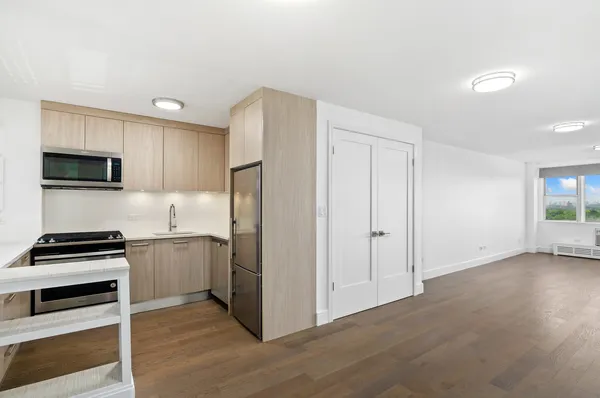 a kitchen with a refrigerator and a stove top oven