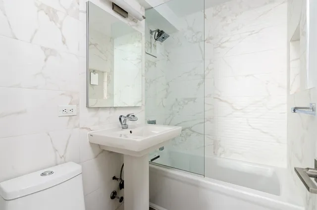 a bathroom with a sink a toilet and shower