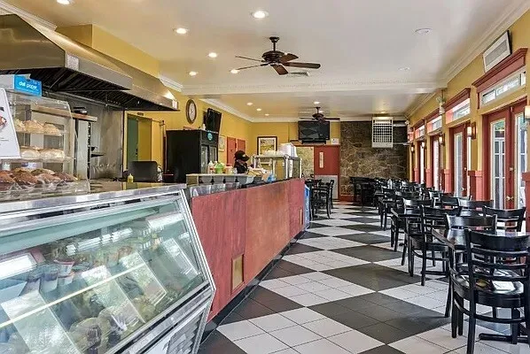 a view of a kitchen with kitchen island stainless steel appliances a table and chairs in it