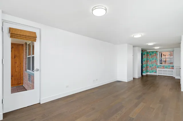 an empty room with wooden floor and a window
