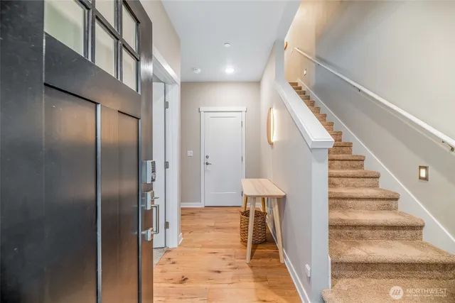 a view of a hallway with wooden floor and entryway