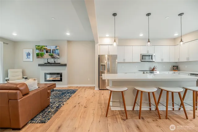 a living room with furniture a fireplace and kitchen view