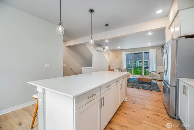 a large white kitchen with a large window a oven and stainless steel appliances