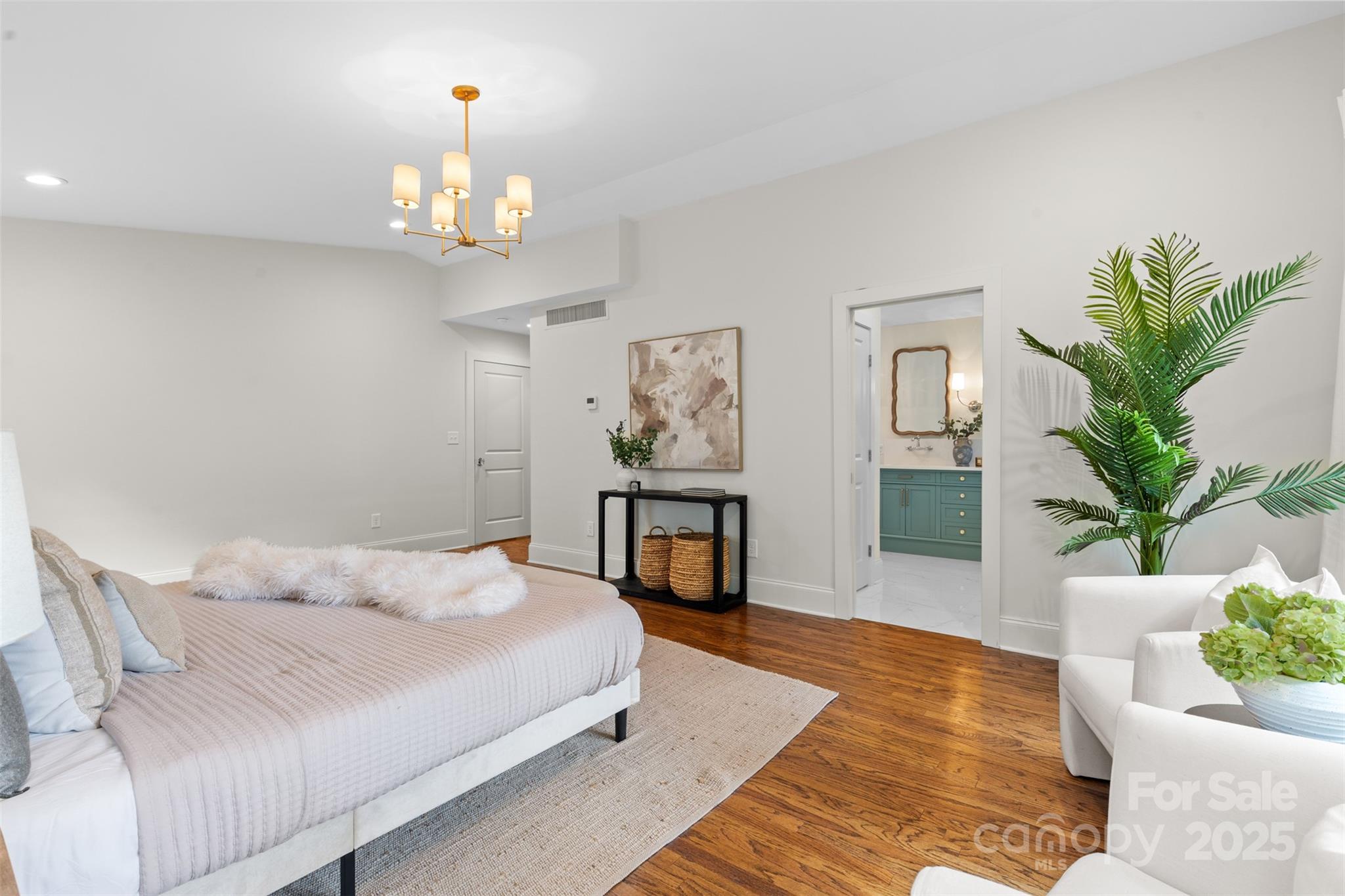 5611 Robinhood Road Charlotte, NC 28211 - Photo 28 of 48 a bedroom with a large bed a chandelier and a couch