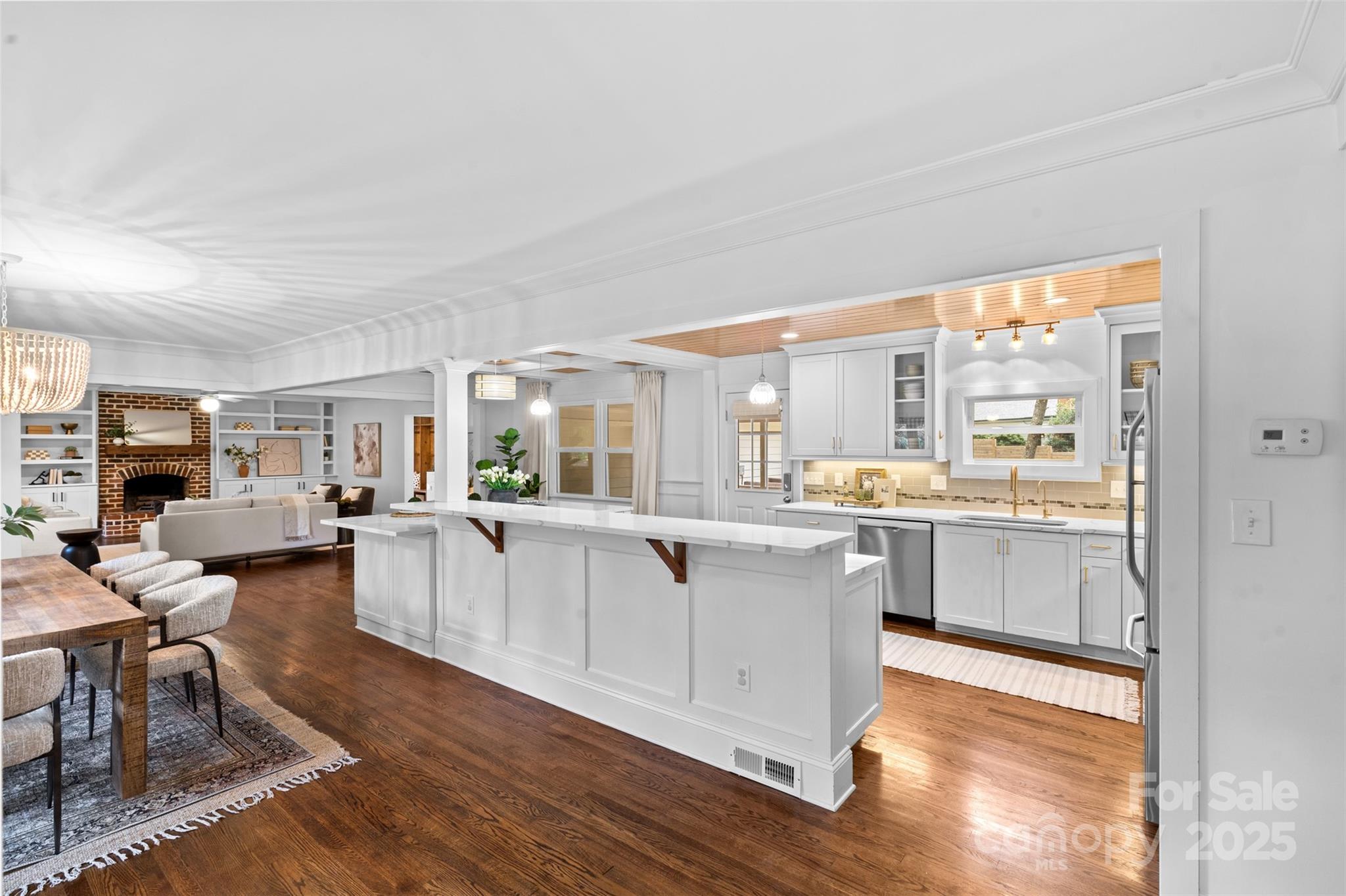 5611 Robinhood Road Charlotte, NC 28211 - Photo 3 of 48 a large white open kitchen with stainless steel appliances granite countertop a stove and white cabinets with wooden floor
