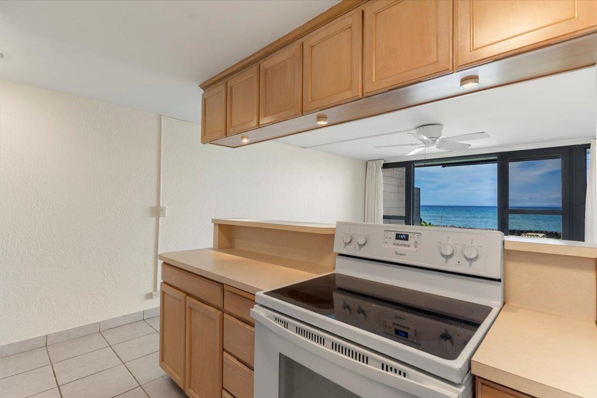 3785 Lower Honoapiilani Road, Unit 107 Lahaina, HI 96761 - Photo 11 of 30 a kitchen with a stove and white cabinets