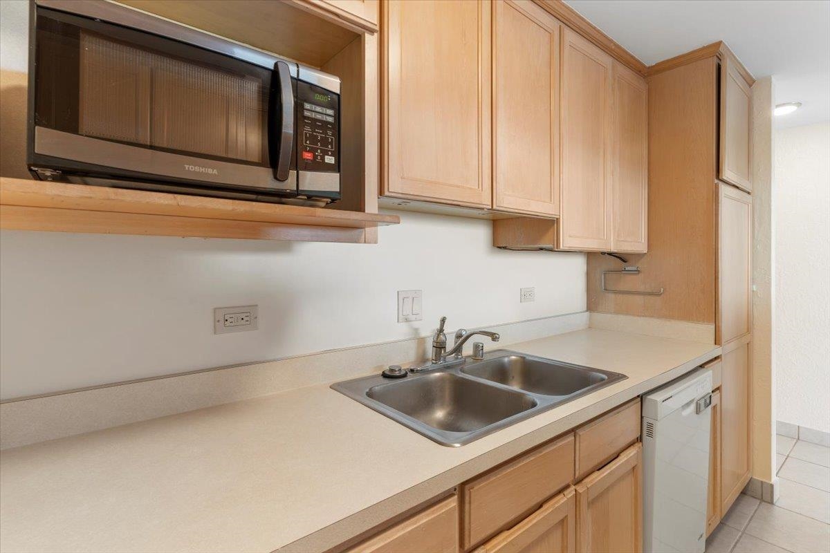 3785 Lower Honoapiilani Road, Unit 107 Lahaina, HI 96761 - Photo 10 of 30 a kitchen with stainless steel appliances granite countertop a sink a microwave and cabinets