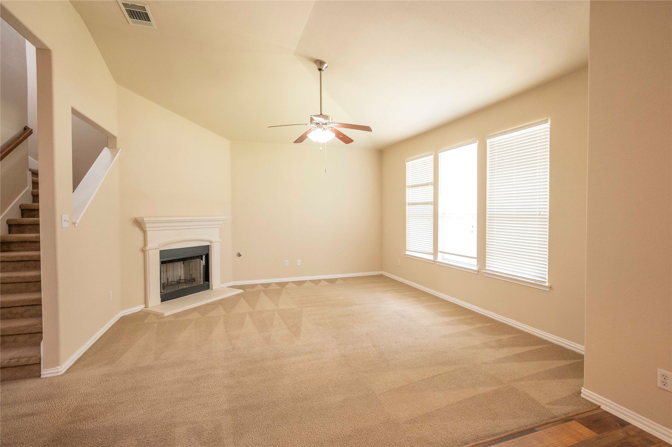 2070 Intrepid Drive Buda, TX 78610 - Photo 18 of 31 A spacious living room features a classic fireplace, vaulted ceilings, and natural light from multiple windows.