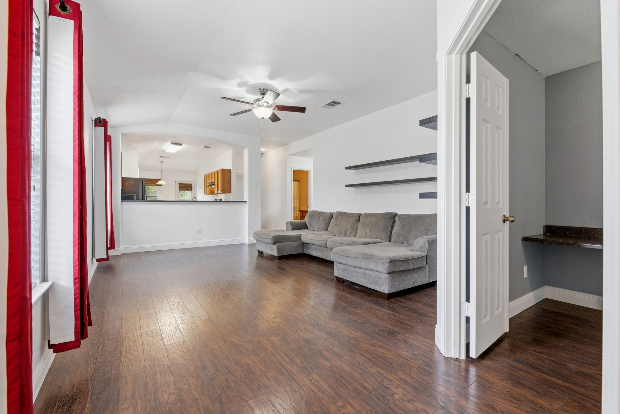 12601 Waynespur Lane Elgin, TX 78621 - Photo 6 of 38 Rich hardwood-style flooring extends through this open-concept living space with a convenient built-in desk nook.
