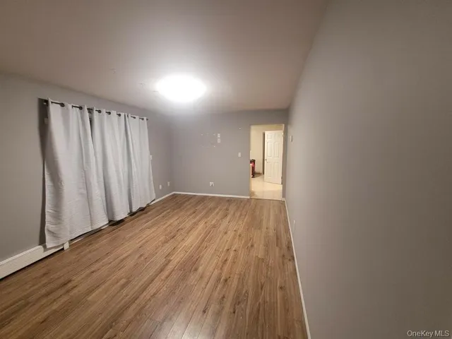 a view of a room with wooden floor and window