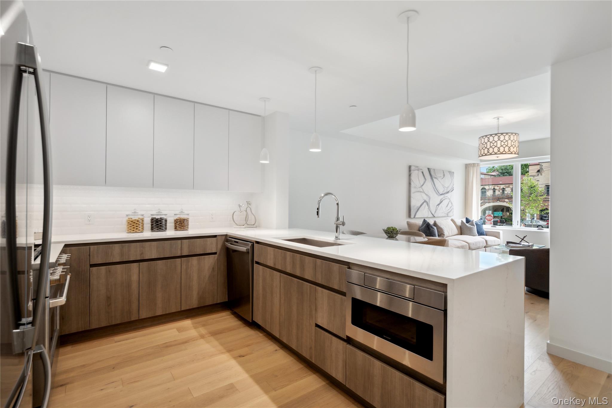 218 Middle Neck Road, Unit 302 Great Neck, NY 11021 - Photo 28 of 30 Kitchen with sink, light hardwood / wood-style flooring, decorative light fixtures, white cabinetry, and stainless steel appliances
