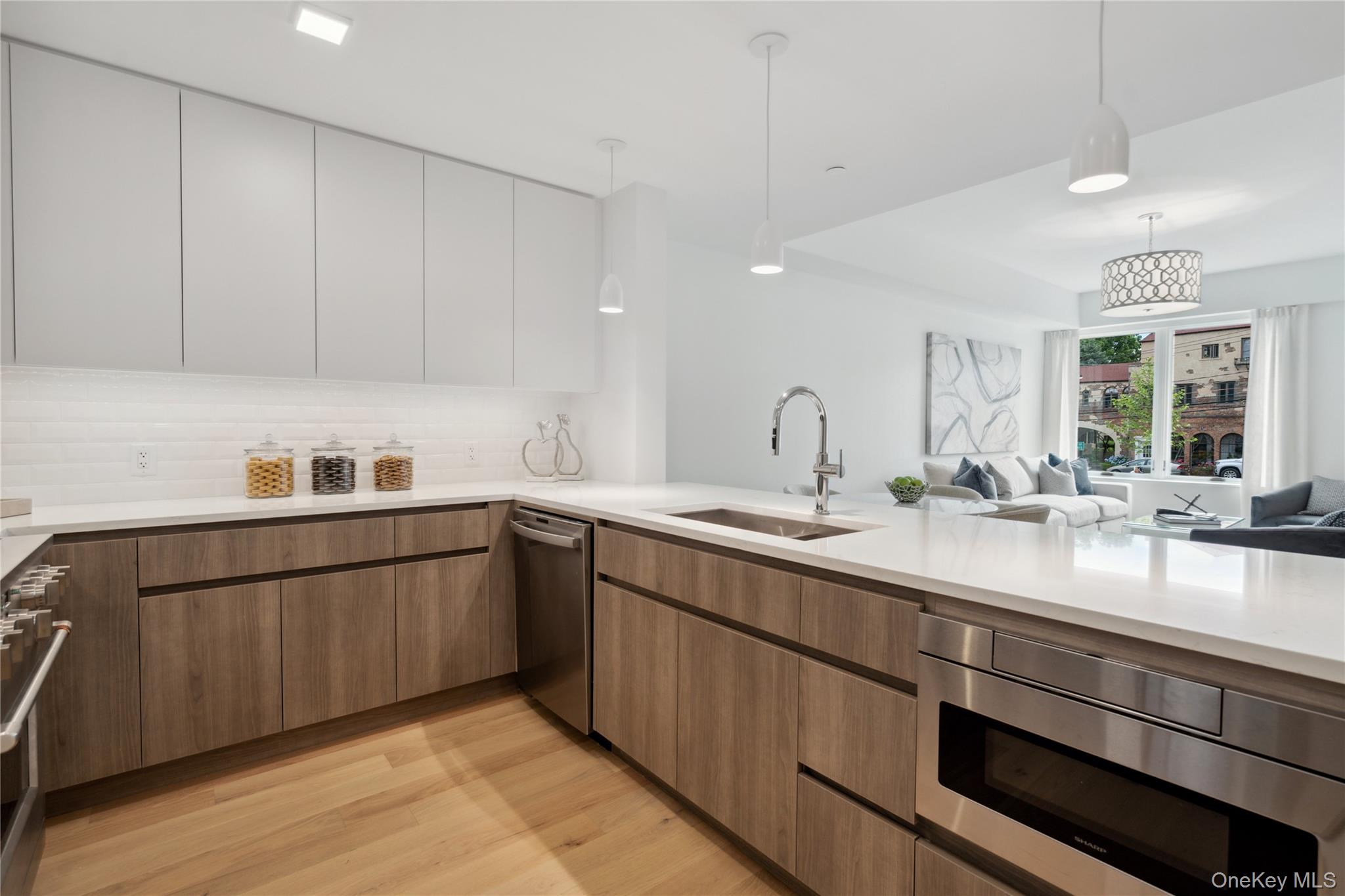 218 Middle Neck Road, Unit 302 Great Neck, NY 11021 - Photo 29 of 30 Kitchen with white cabinetry, sink, dishwasher, pendant lighting, and light wood-type flooring