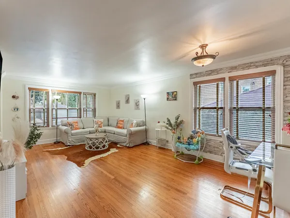 a living room with furniture floor to ceiling window and wooden floor