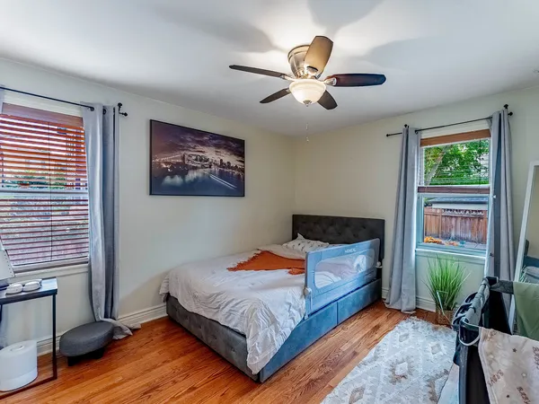 a bedroom with a large bed chandelier and a window