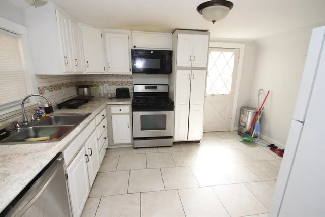 a kitchen with a sink a stove and cabinets