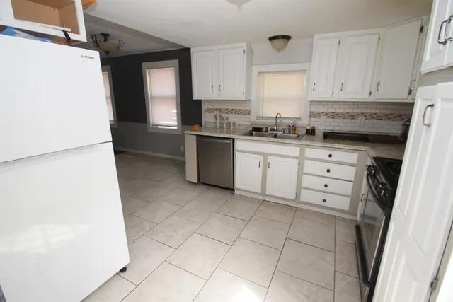 a kitchen with granite countertop cabinets and white appliances