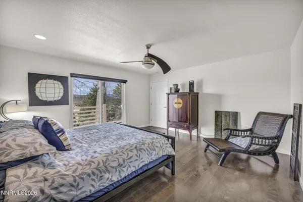 a spacious bedroom with a bed and a flat screen tv