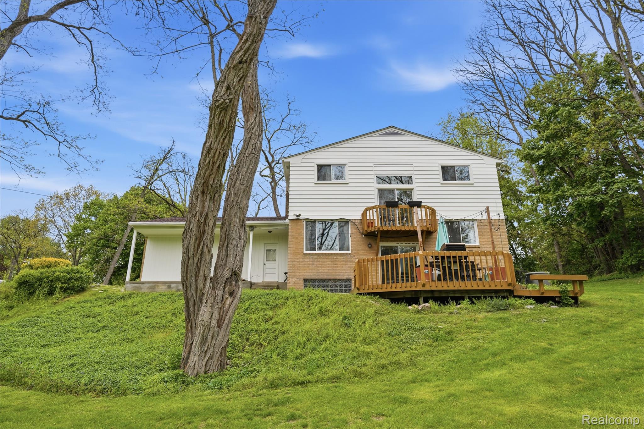 47129 Dunsany Road Northville, MI 48167 - Photo 34 of 49 Rear view of house with a lawn, a deck, and brick siding